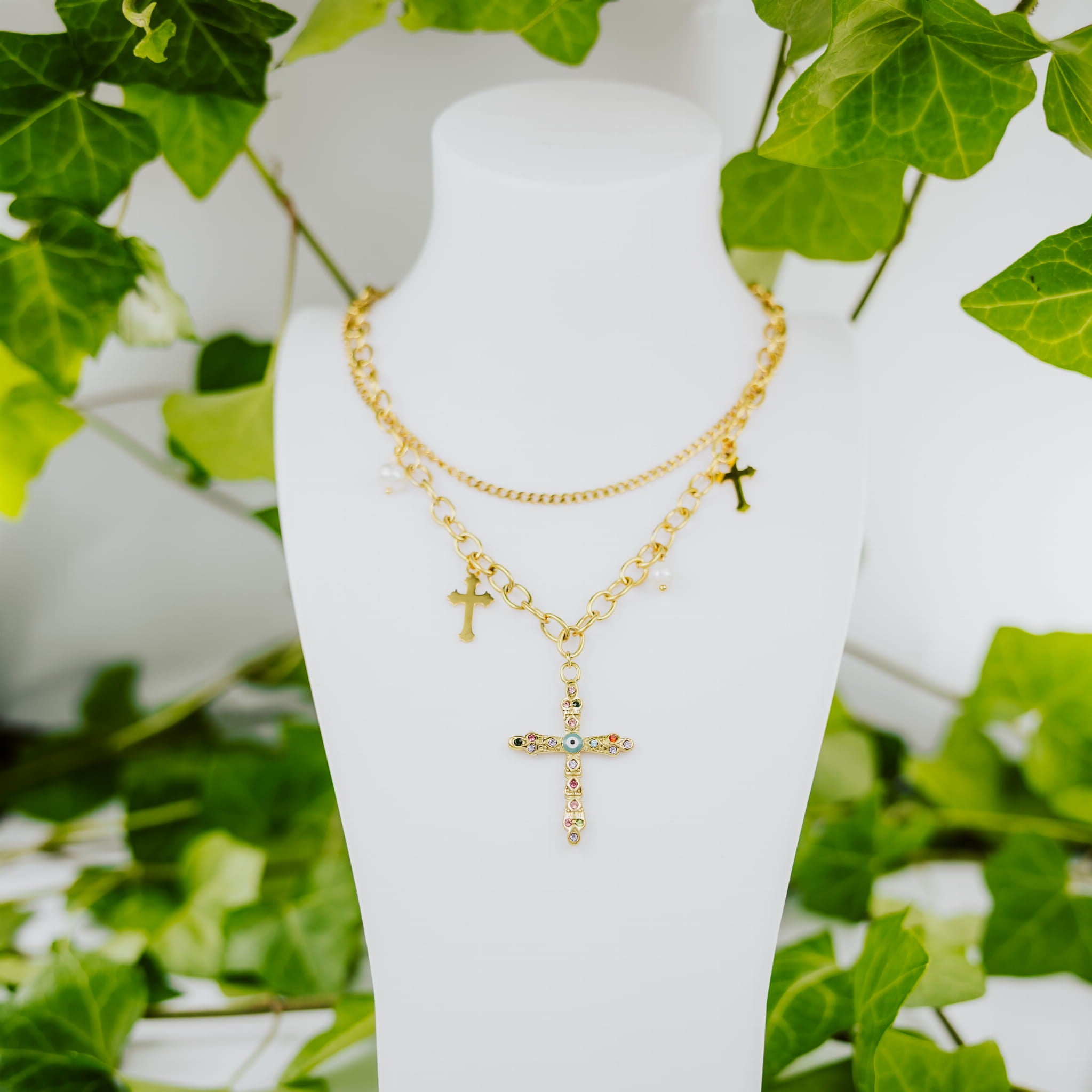 Doppelte Goldkette mit einem Kreuz, das mit bunten Steinen besetzt ist