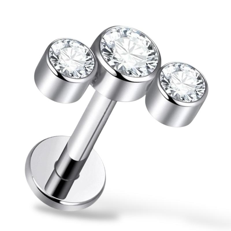 Labret-Ohrring aus Titan und Gold mit drei Zirkonen.